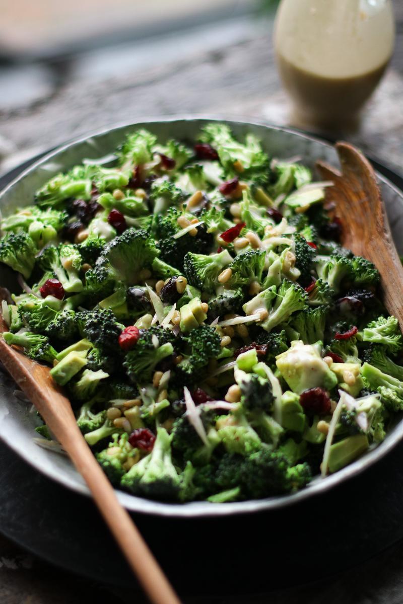a bowl of salad with broccoli and cranberries
