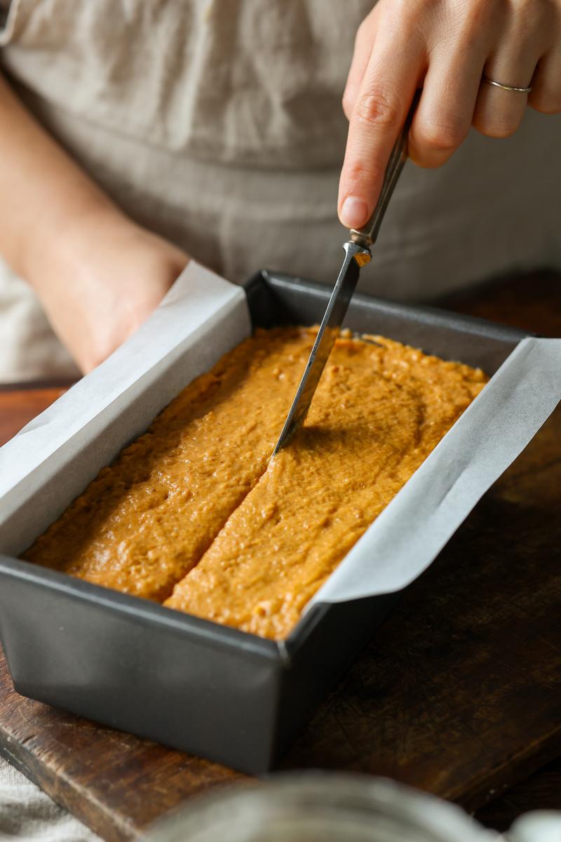 a no egg baker using a knife to score the batter of the fall loaf