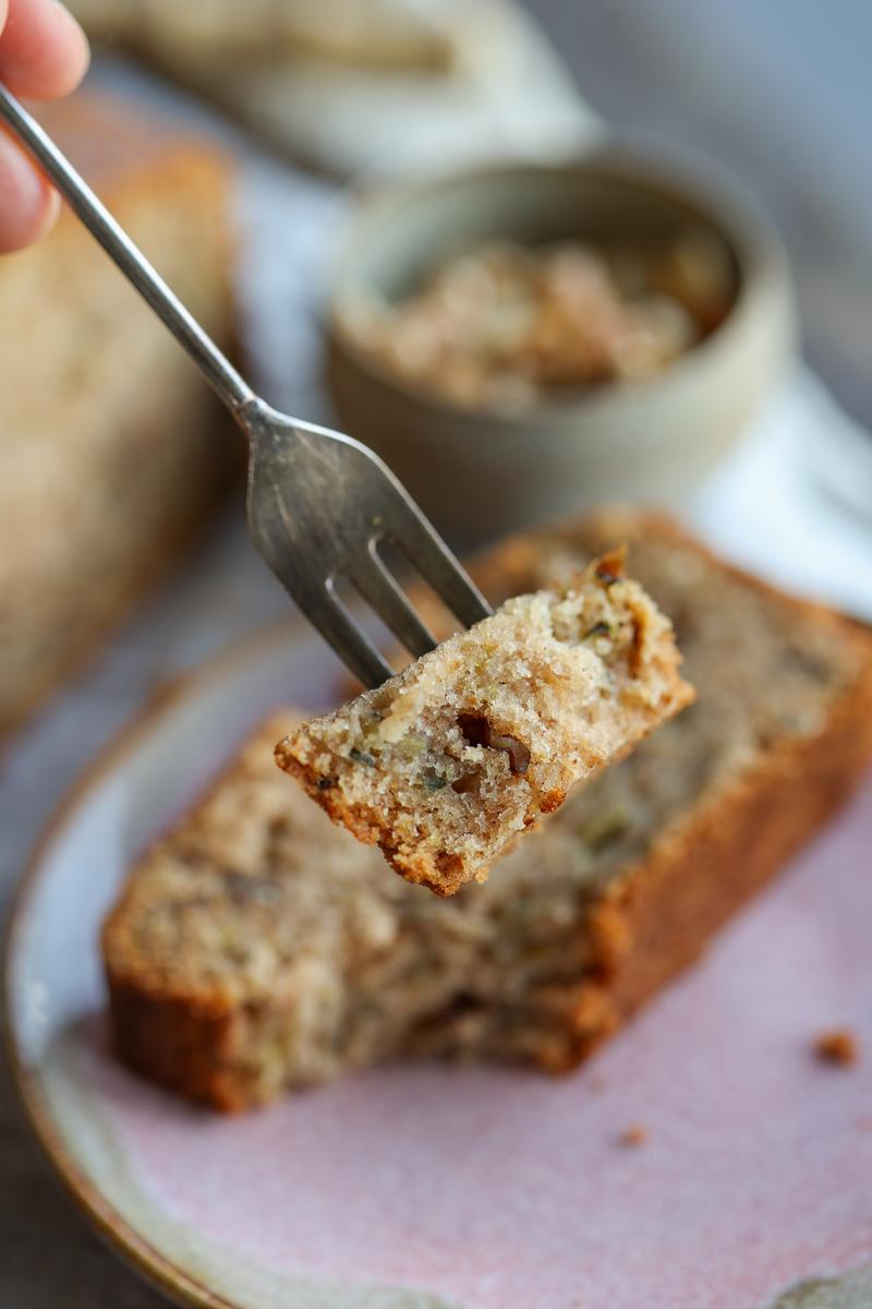 a vegan taking a forkful of the easy courgette bread recipe