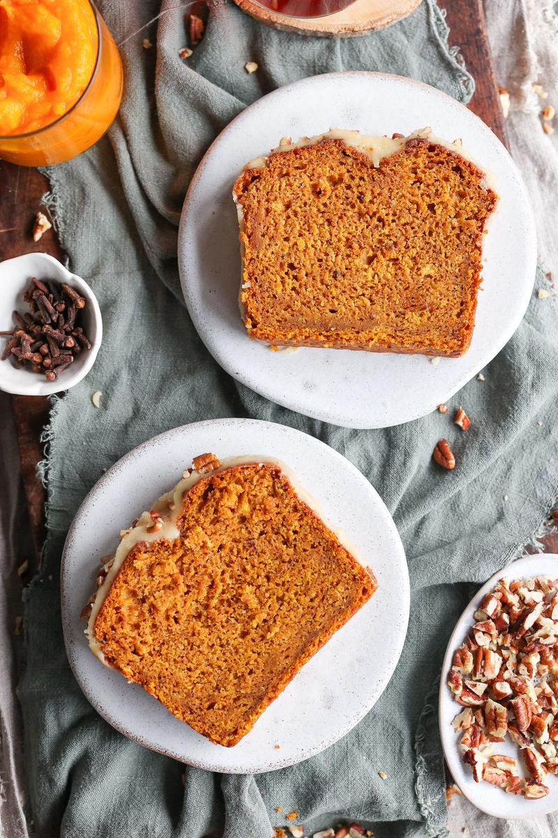 two slices of a vegan pumpkin bread recipe on white plates